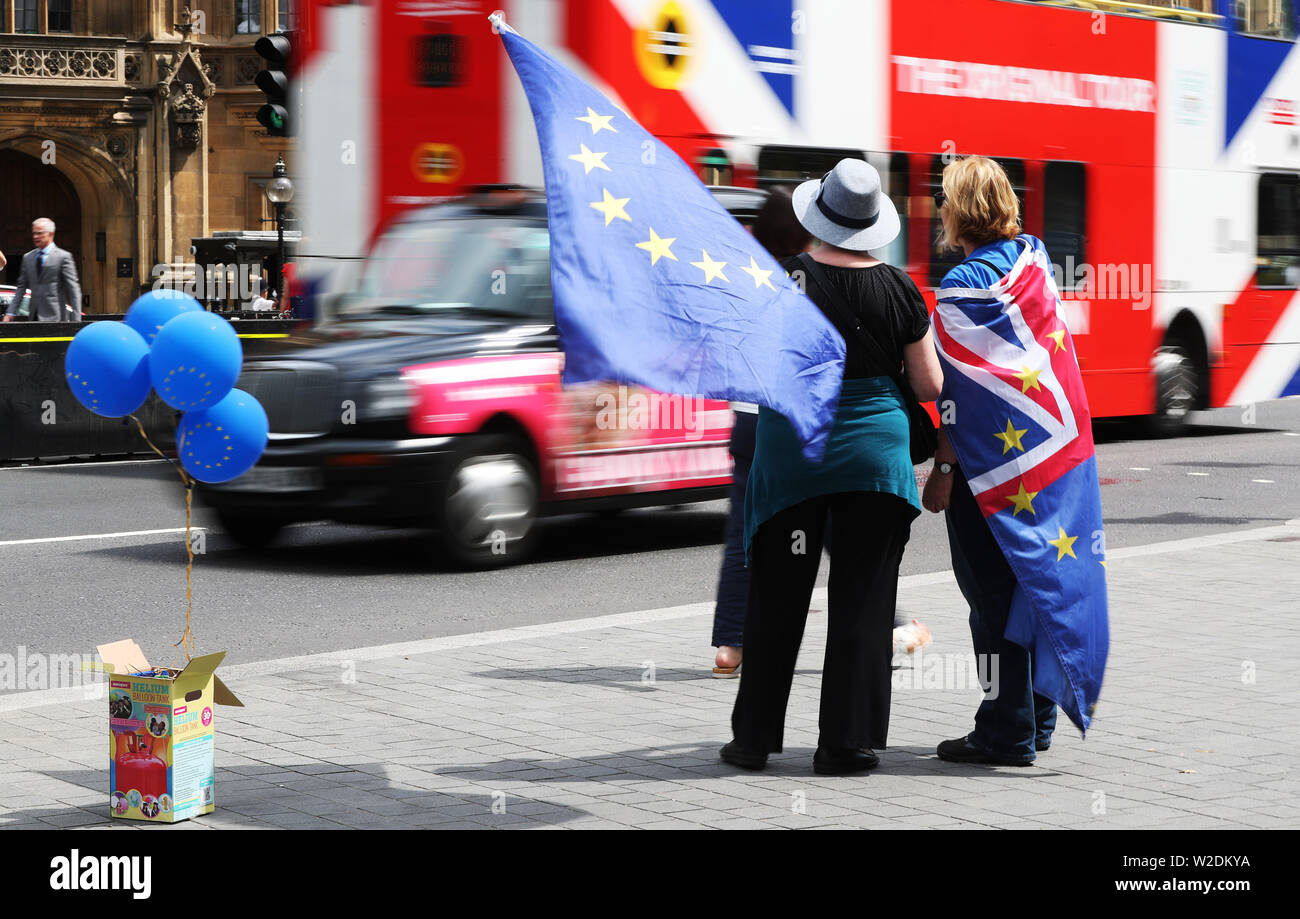 Pro EU activists fly flags of the European Union and Great Britain together whilst stood near the Palace of Westminster. Stock Photo
