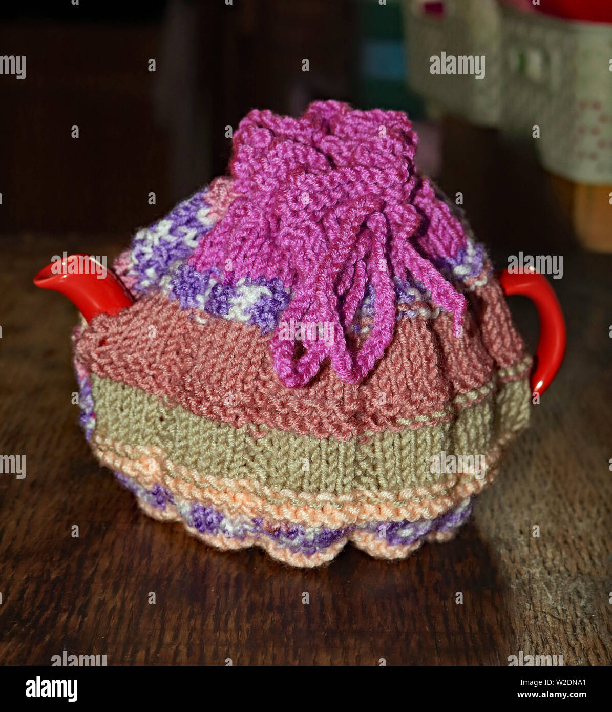 A Hand Knitted Tea Cosy In Brown Orange Green And Purples - 