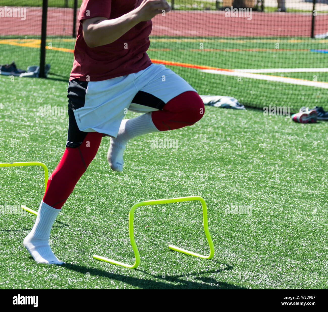 A high school track and field athlete is performing a speed and agility