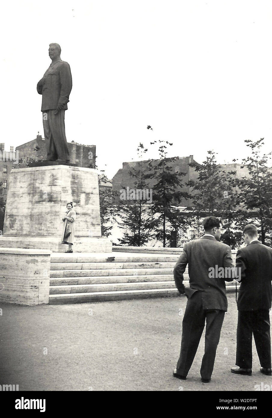 Photograph of two men and a woman in front of the former statue of Joseph Stalin on what is now Karl Marx Allee in Berlin, taken in 1955 (statue removed in 1961?) Stock Photo