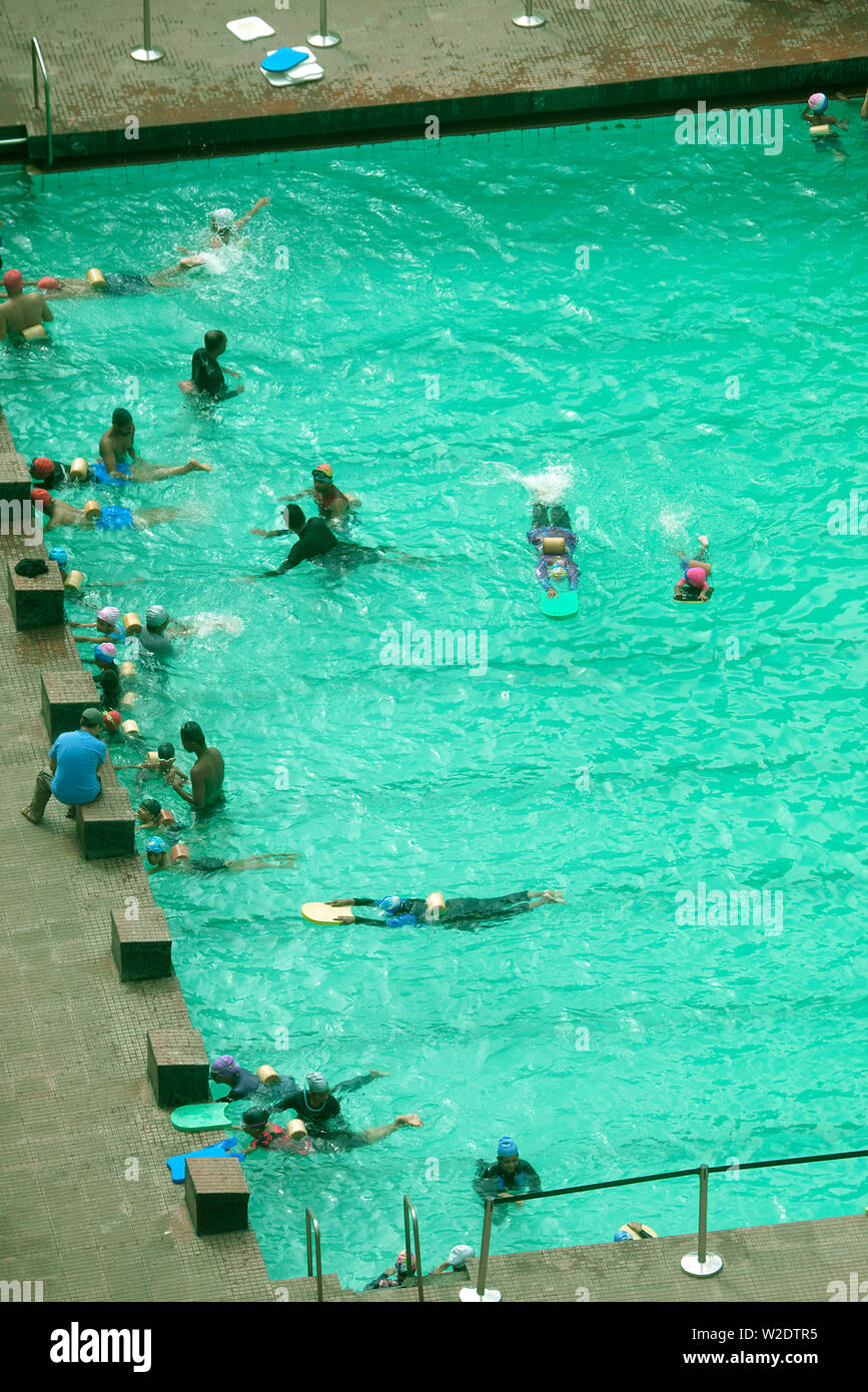 CHILDREN LEARNING TO SWIM IN A PUBLIC SWIMMING POOL IN MUMBAI, INDIA
