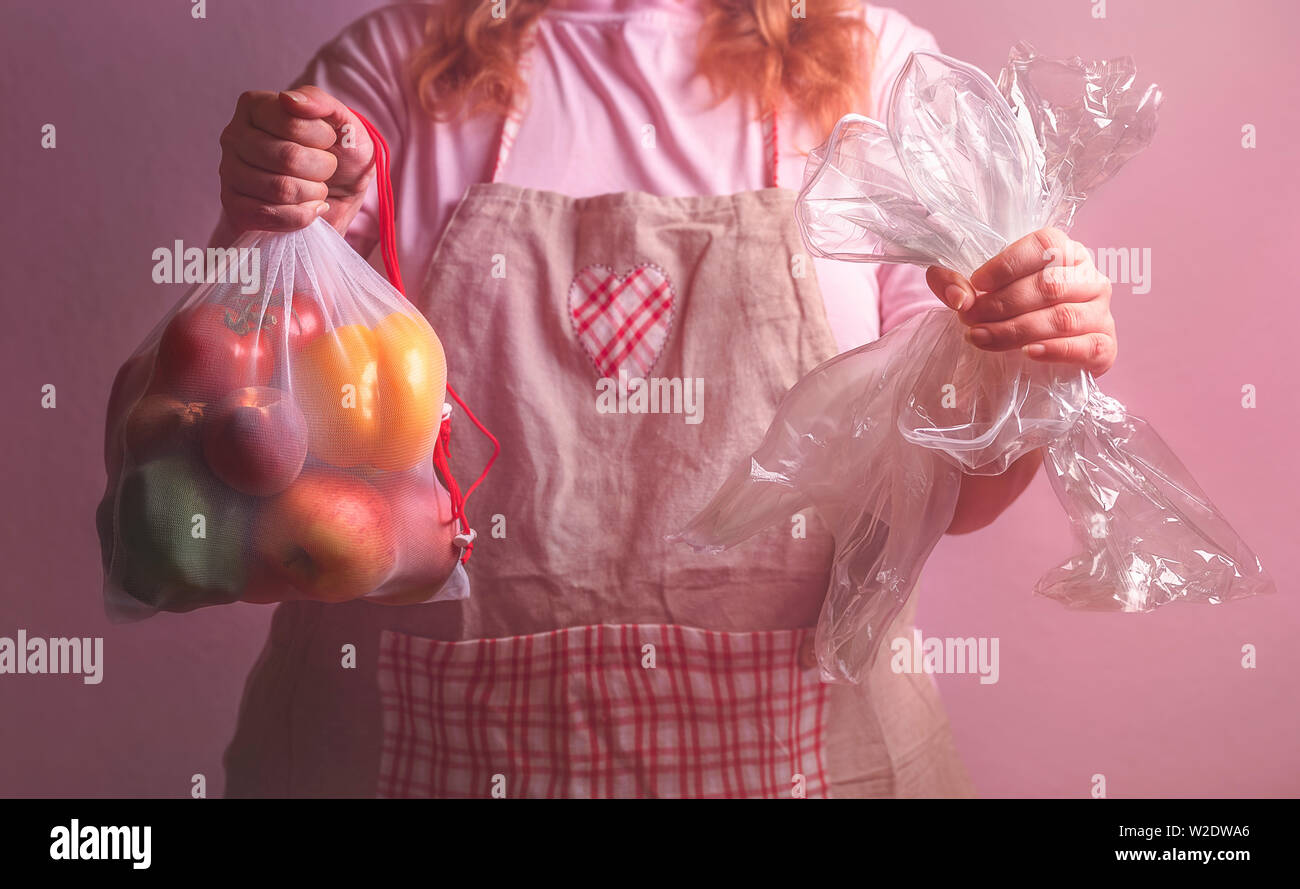 Sustainable lifestyle concept with a woman holding an eco-friendly bag with vegetables and empty groceries plastic wrappers. Plastic-free concept Stock Photo