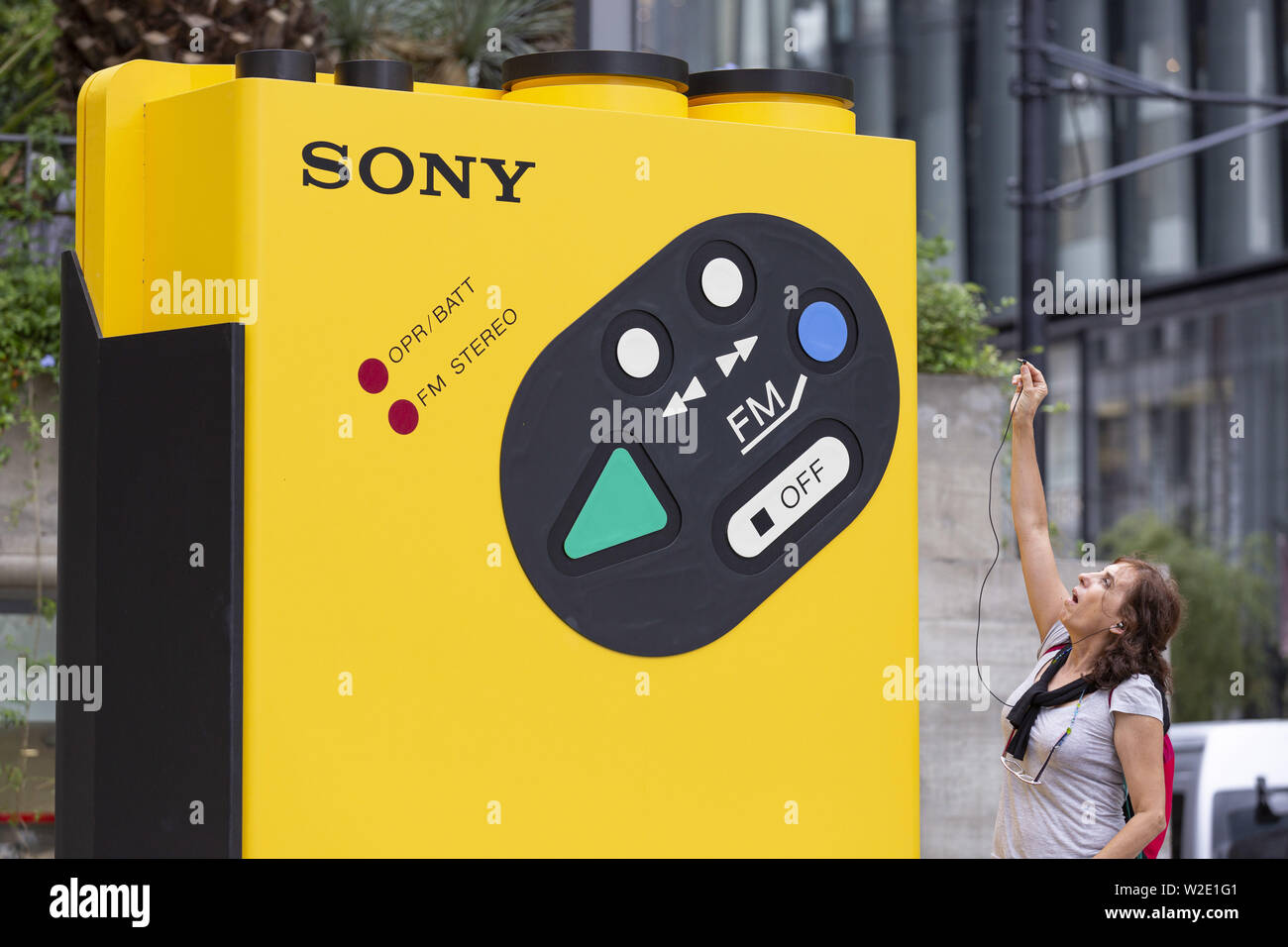 Tokyo, Japan. 8th July, 2019. A woman tries to plugin to a huge portable  audio player ''