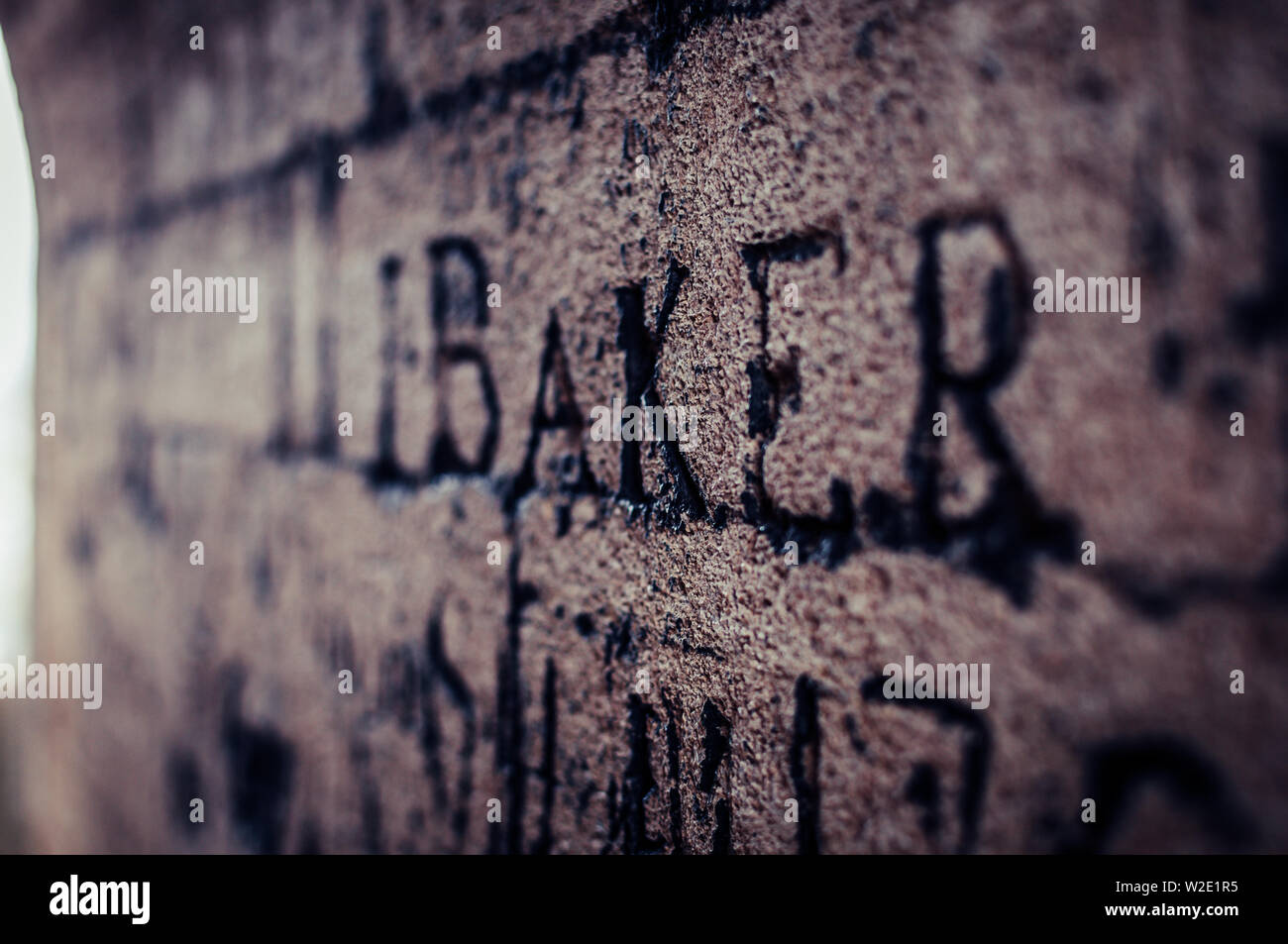 A piece of very old graffiti in Oxford - ether into a stone wall reads the word Baker. Stock Photo