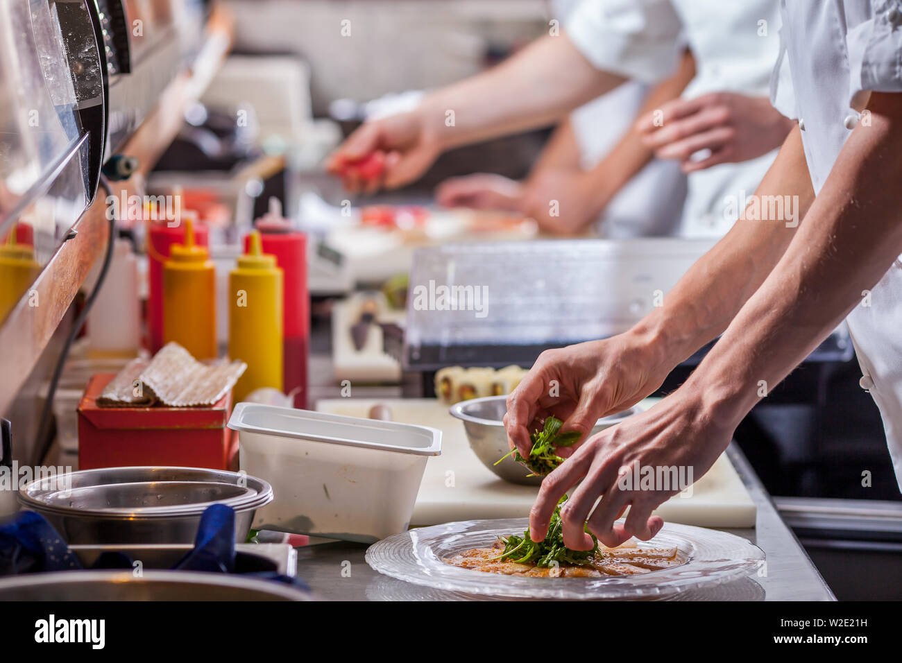 male cooks preparing meals in restaurant kitchen Stock Photo