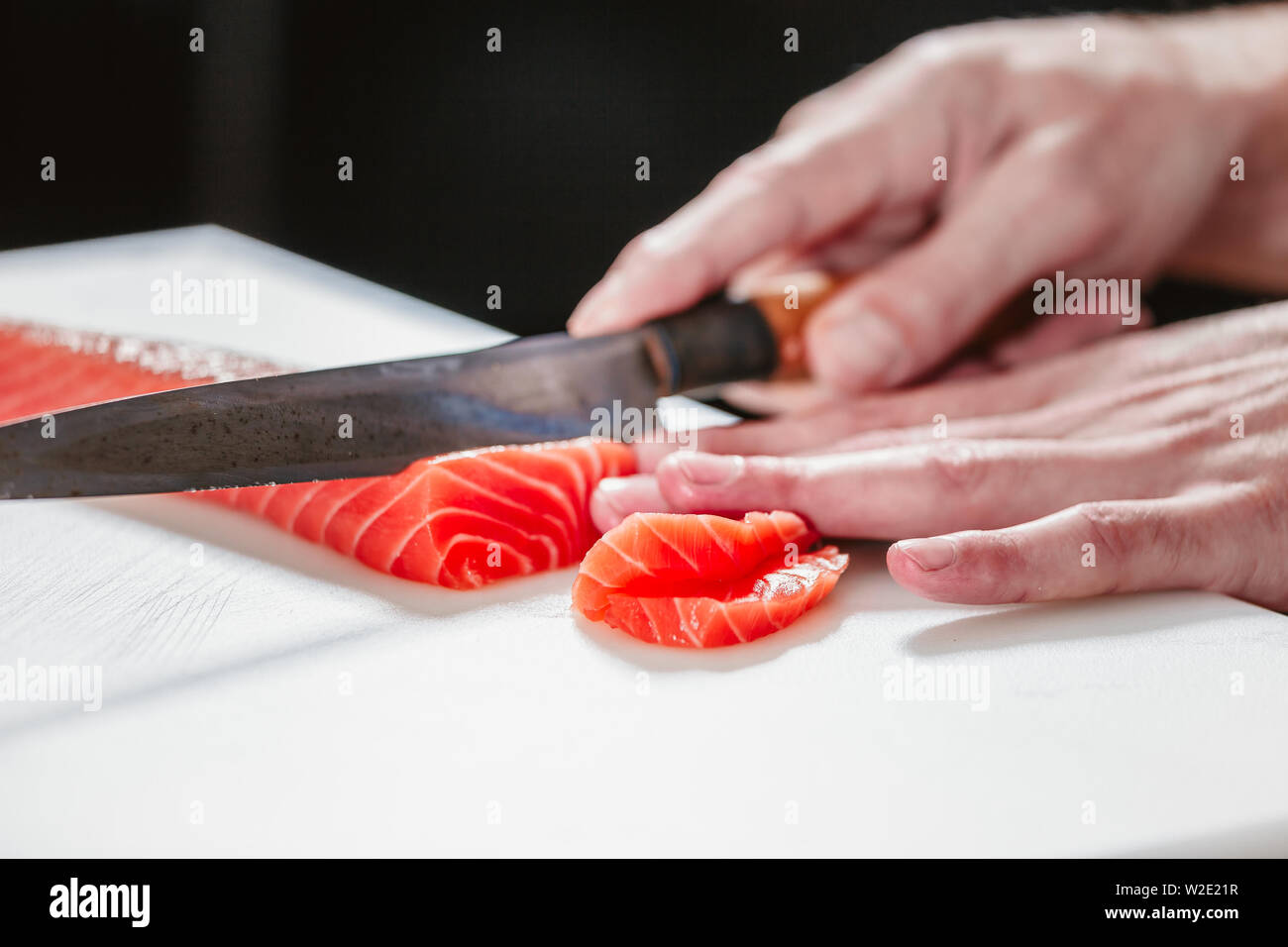 Cook cutting fresh salmon fillet Stock Photo