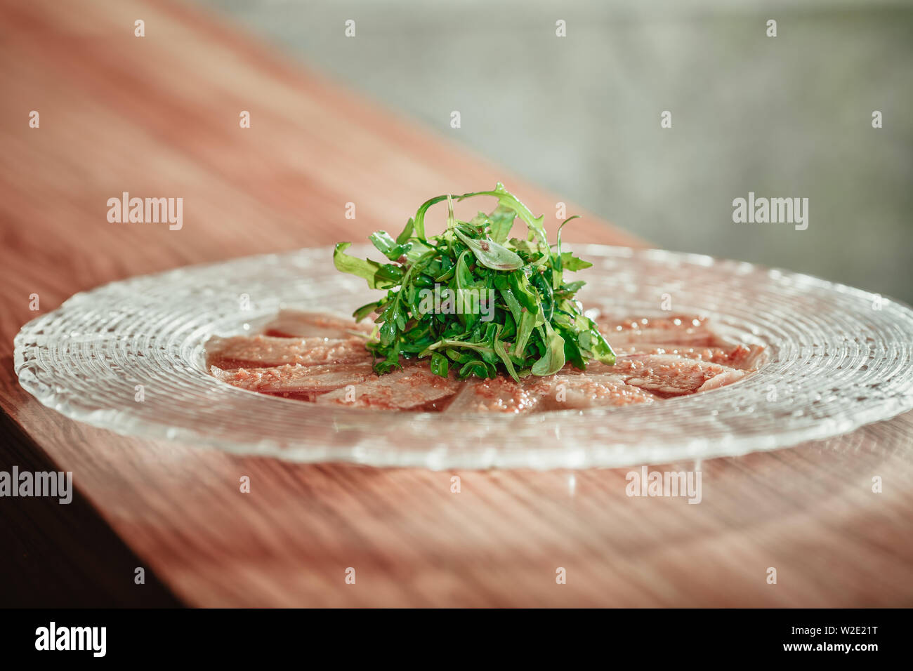Delicious appetizer with herbs on glass plate on wooden table Stock Photo