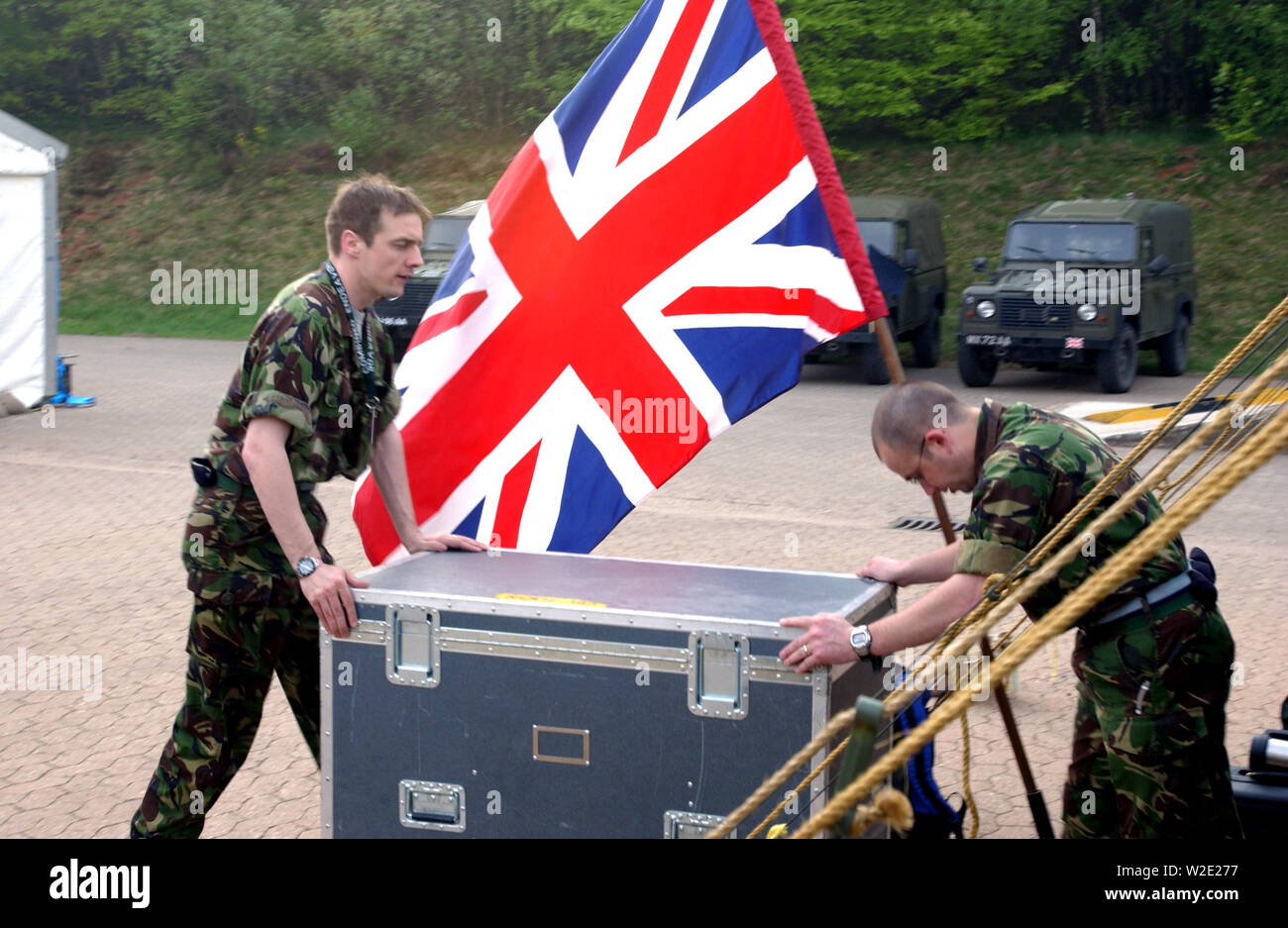 Royal Army (British) Soldiers push equipment past the National Ensign while setting up operations at Lager Aulenbach, Germany, during the US European Command (USEUCOM) -sponsored Exercise COMBINED ENDEAVOR. Stock Photo