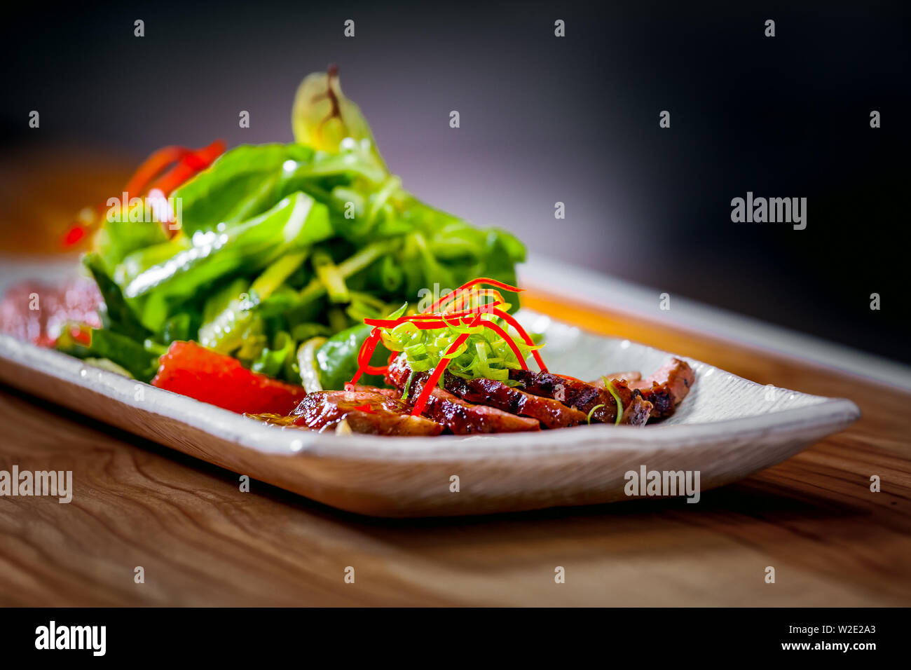 Delicious appetizer with herbs and meat on white plate close up Stock Photo