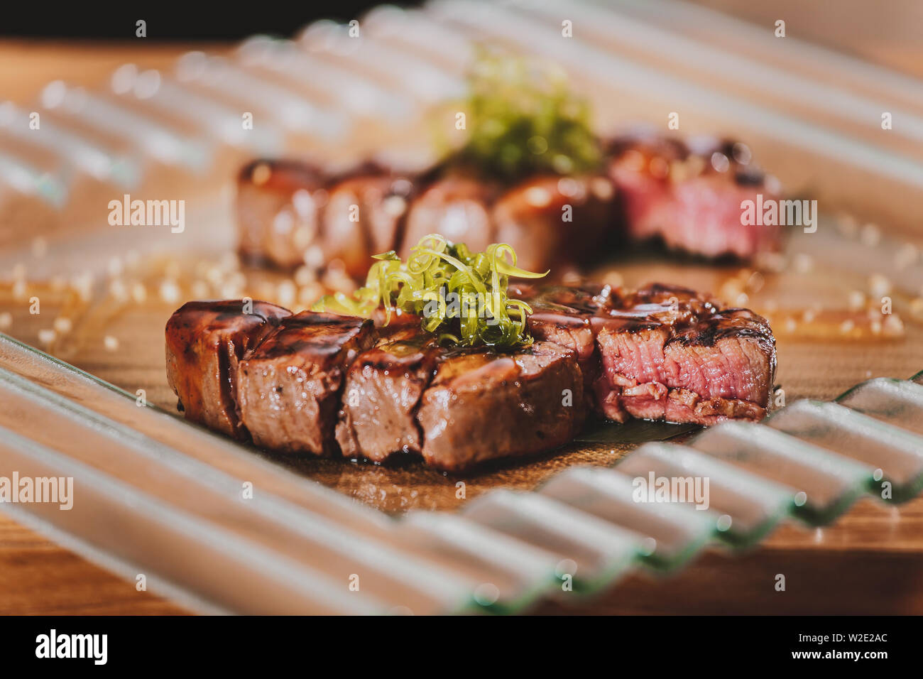 Grilled bbq steaks with herbs on wooden table Stock Photo