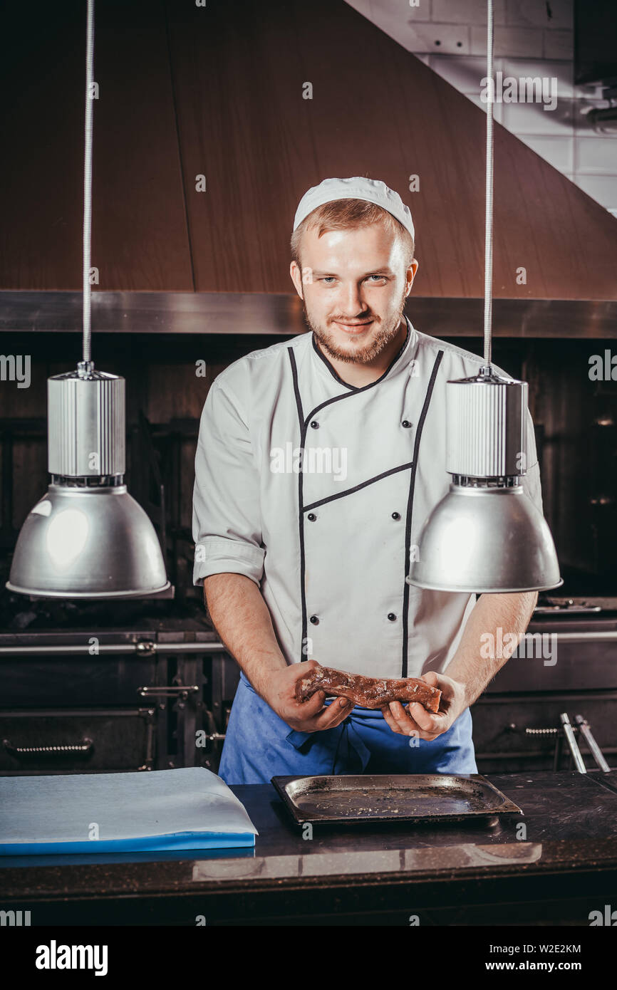 young male cook preparing meal in the restaurant kitchen Stock Photo