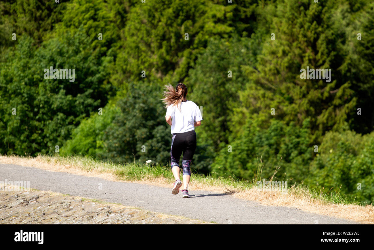 Dundee, Tayside, Scotland, UK. 8th July, 2019. UK weather: Hot sunny weather attracts a female jogger to go jogging around the Clatto Country Park. Stock Photo