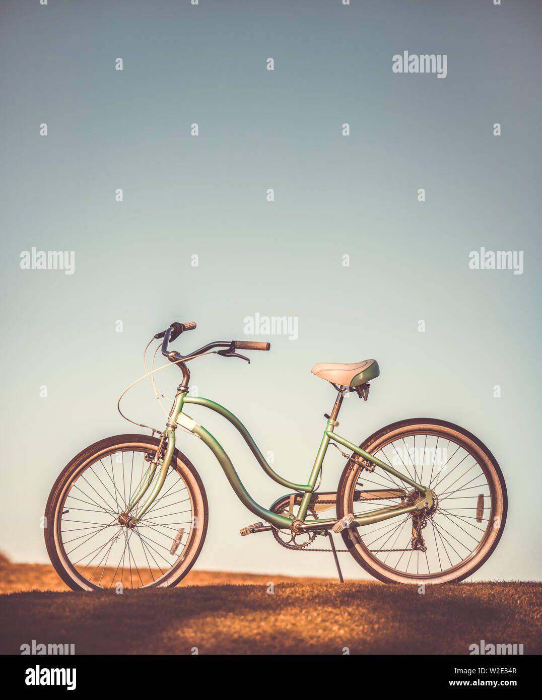 Old retro bicycle on earth and grey sky background Stock Photo