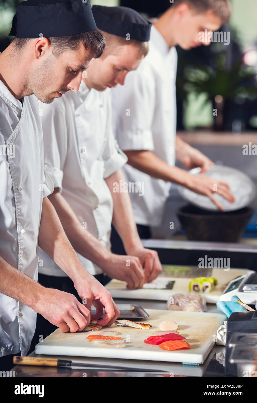 male cooks preparing sushi in the restaurant kitchen Stock Photo