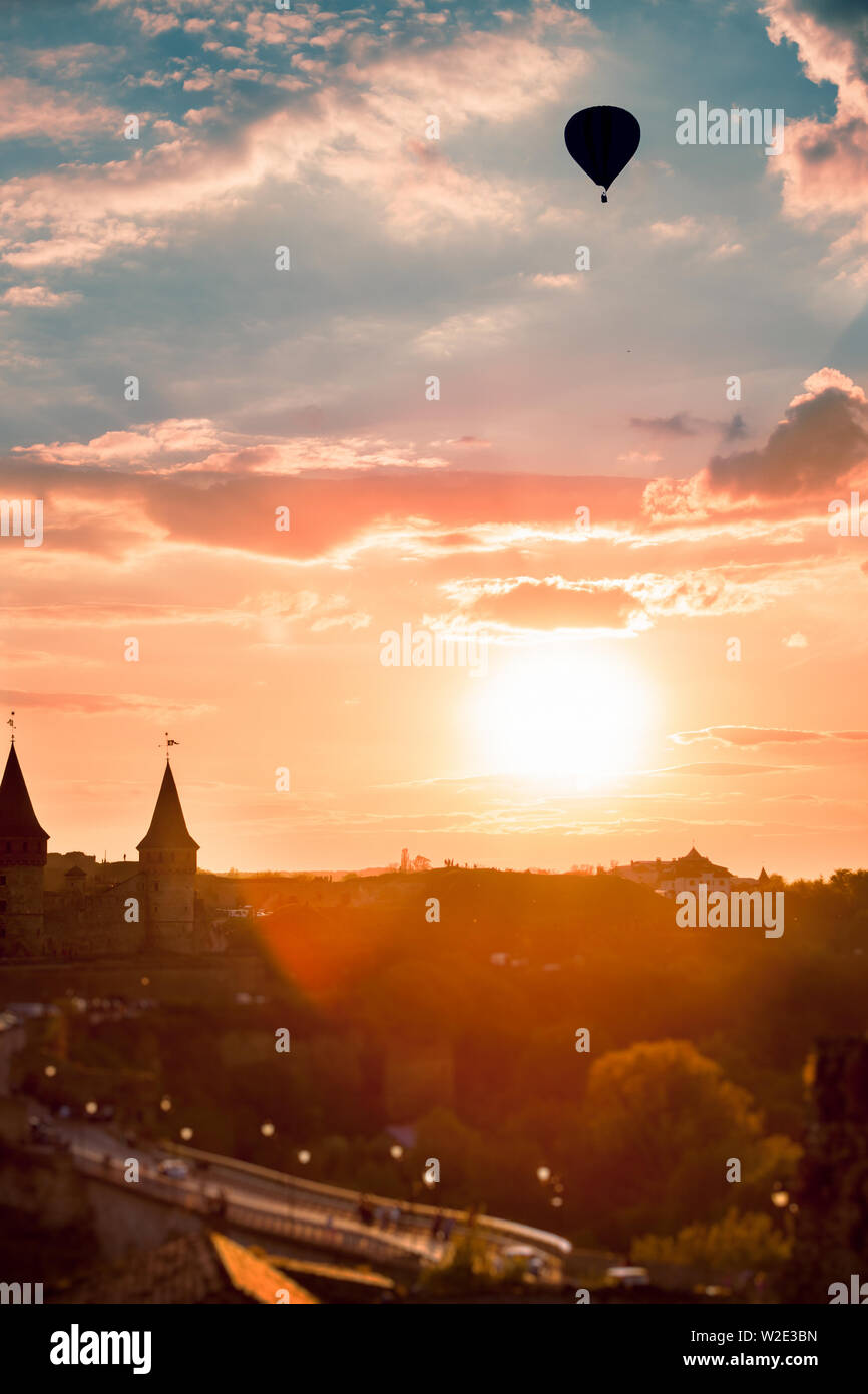 View on the castle in Kamianets Podilskyi and black air balloon during sunset. Ukraine Stock Photo