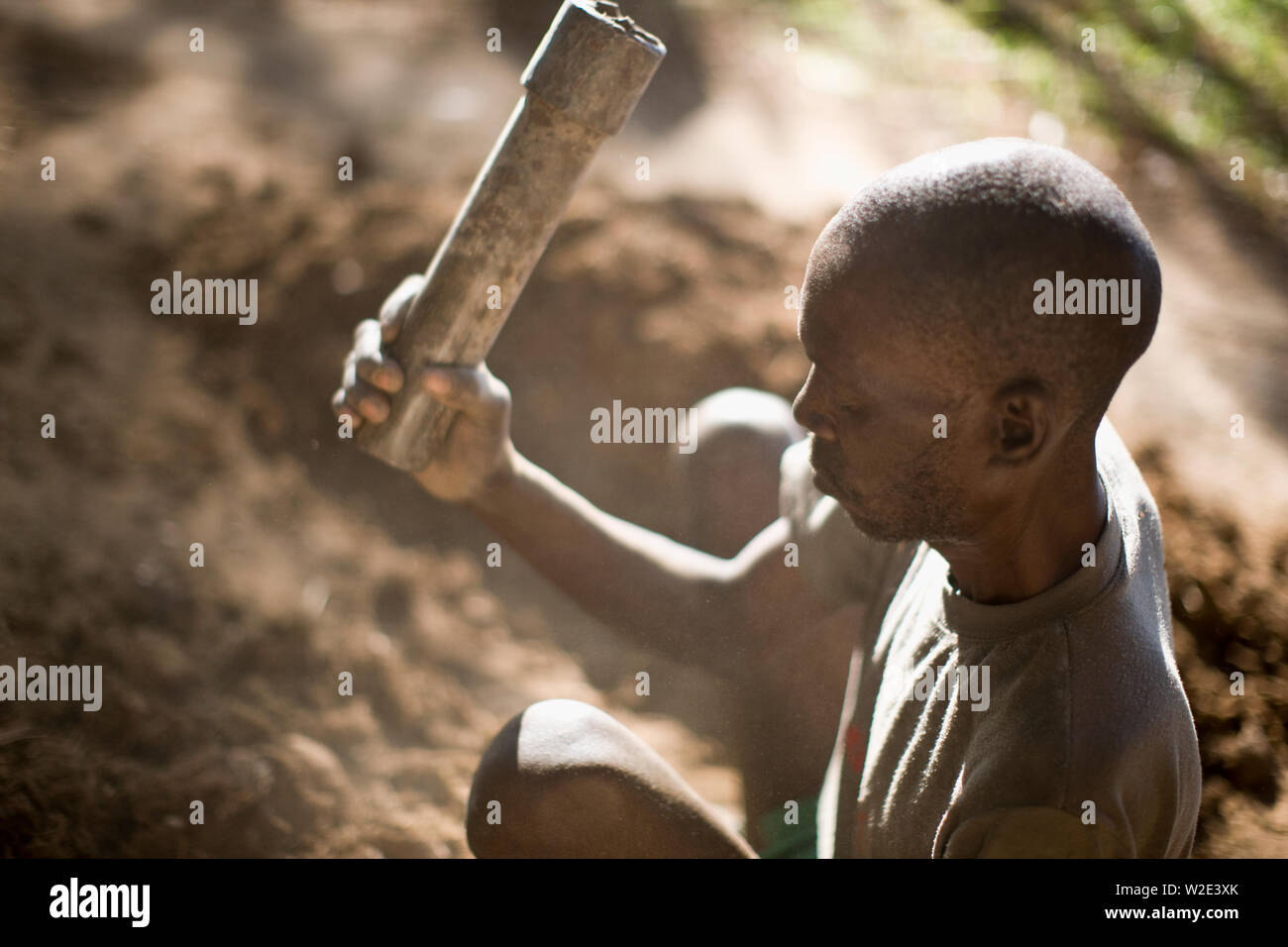 Mature adult man sitting in the garden using tools. Stock Photo