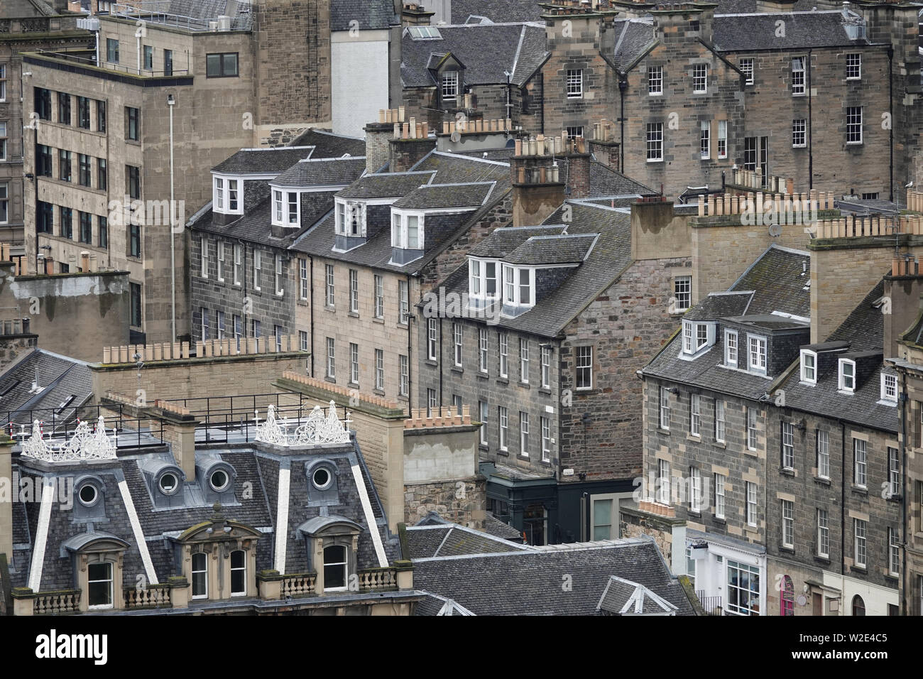Rooftops of old, sandstone buildings in Edinburgh, Scotland are shown from an elevated view during the day. Stock Photo
