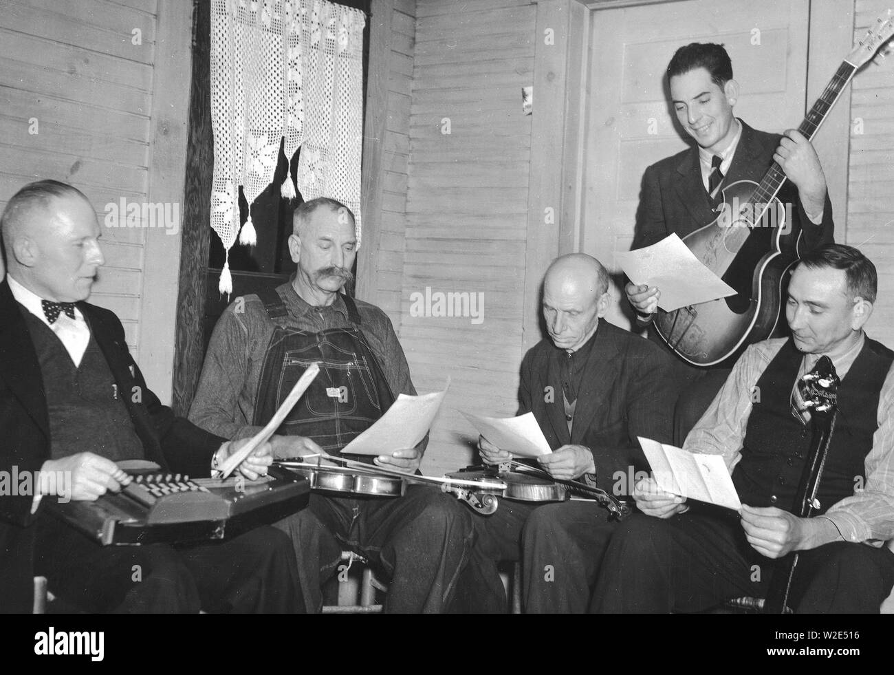 Bog Trotters Band members seated with instruments, Galax, Va. Includes Doc Davis, with autoharp; Crockett Ward, with fiddle; Uncle Alex Dunford, with fiddle; Wade Ward, with banjo; Fields Ward, with guitar ca. 1937 Stock Photo