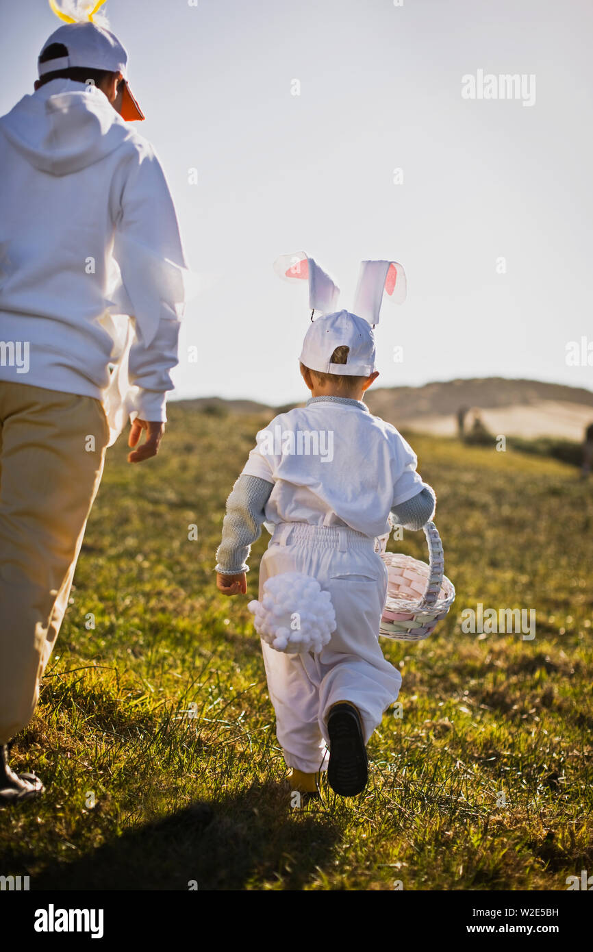 Two brothers in Easter costumes on an Easter egg hunt Stock Photo