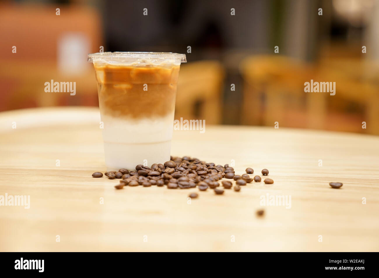 Take away Latte with Coffee bean around on the wood table Stock Photo