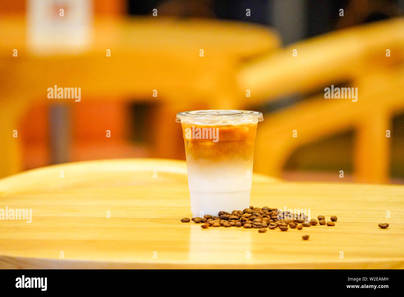 Take away Latte with Coffee bean around on the wood table Stock Photo