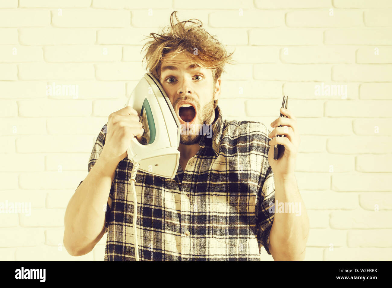 Handsome Surprised Man With Messy Hair With White Iron At