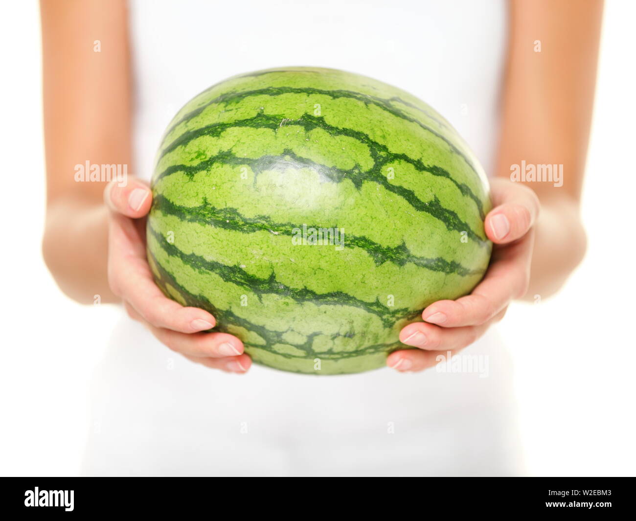 Watermelon. Woman showing whole watermelon on isolated white background. Closeup of water melon. Stock Photo