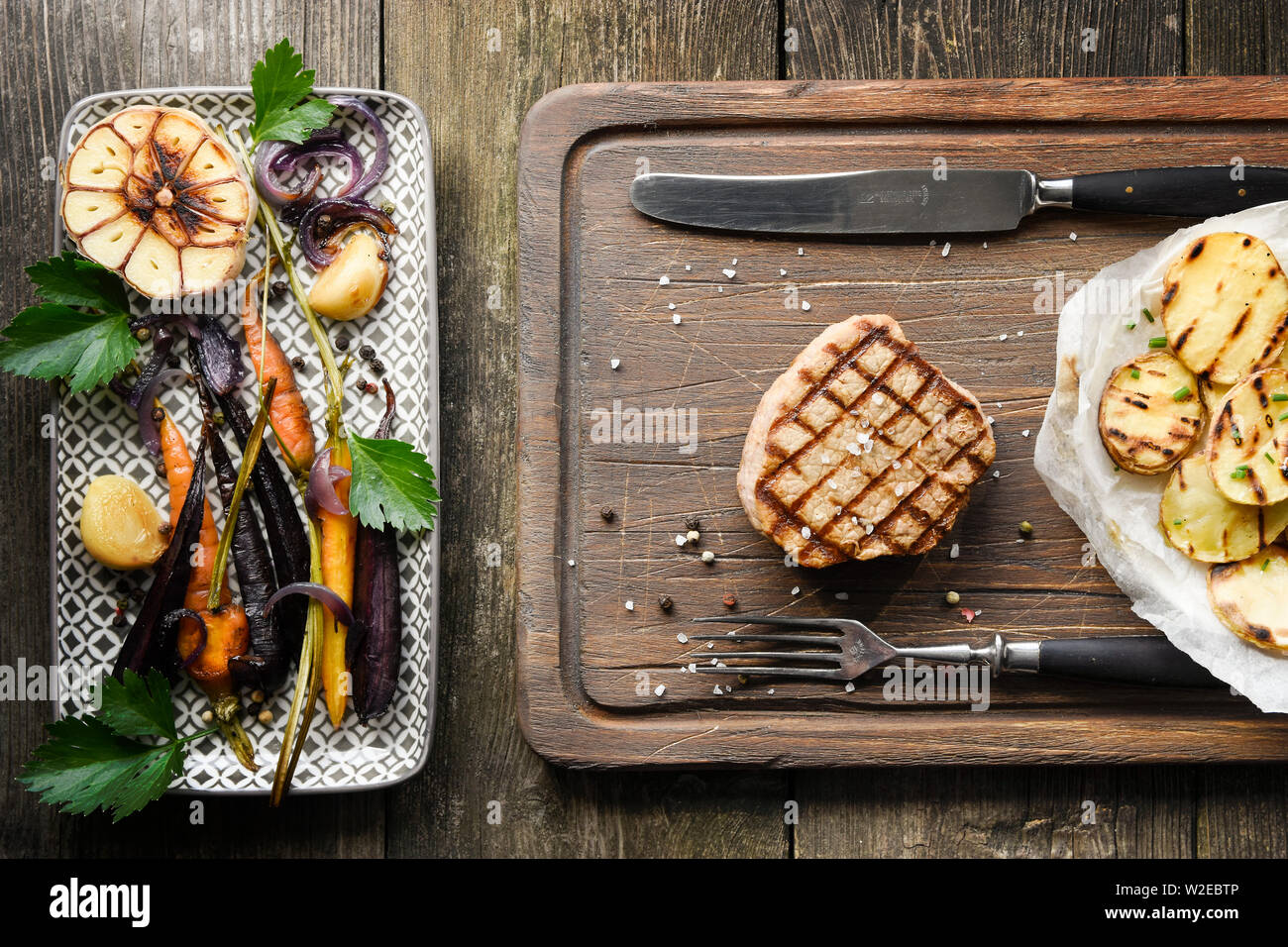 Steak and grilled vegetables from above on wood table Stock Photo