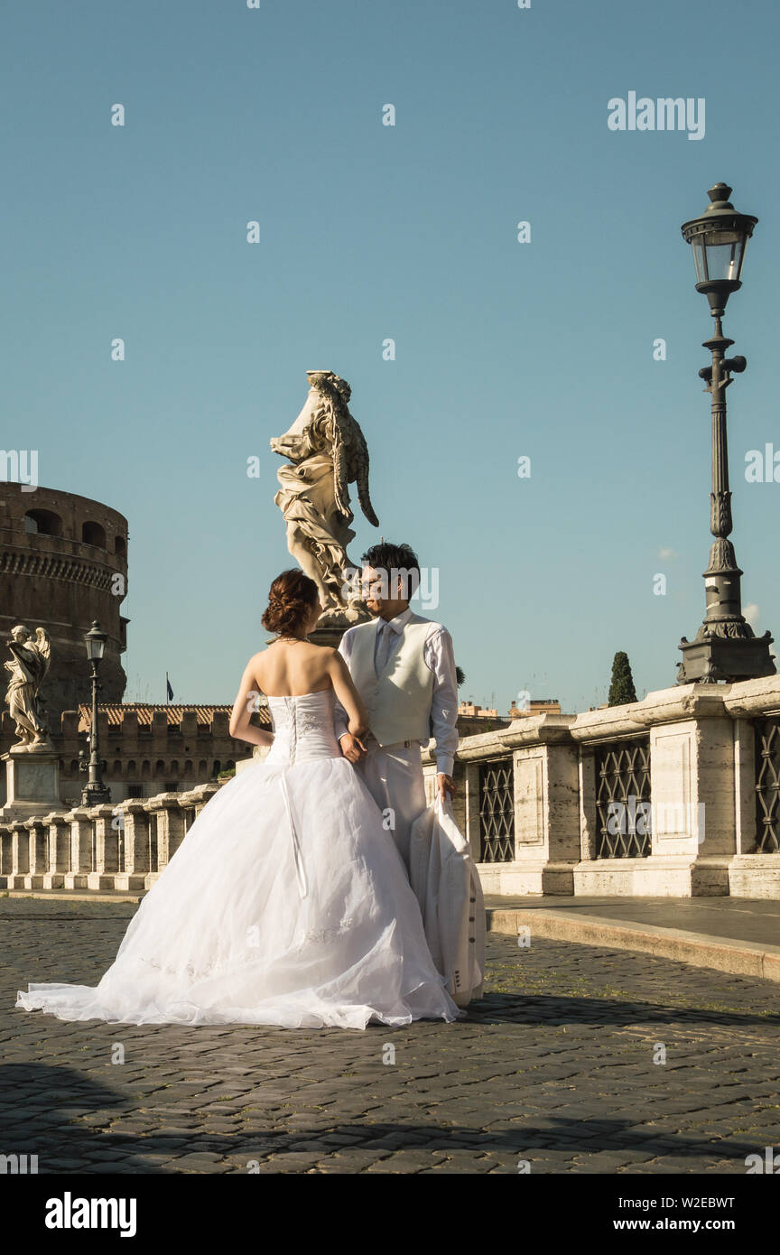 Rome, Italy - July 22nd 2014: Asian couple posing for a wedding photo session in front of Castel Sant Angelo Stock Photo