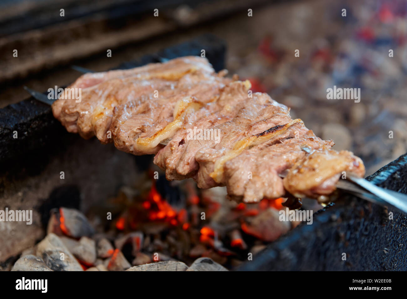 Spit roasted lamb meat on charcoal grill in a restaurant Stock Photo