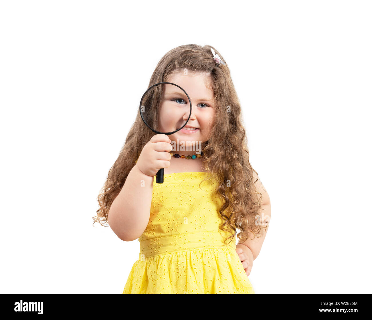 Little girl child looking through a magnifying glass on white background. Stock Photo