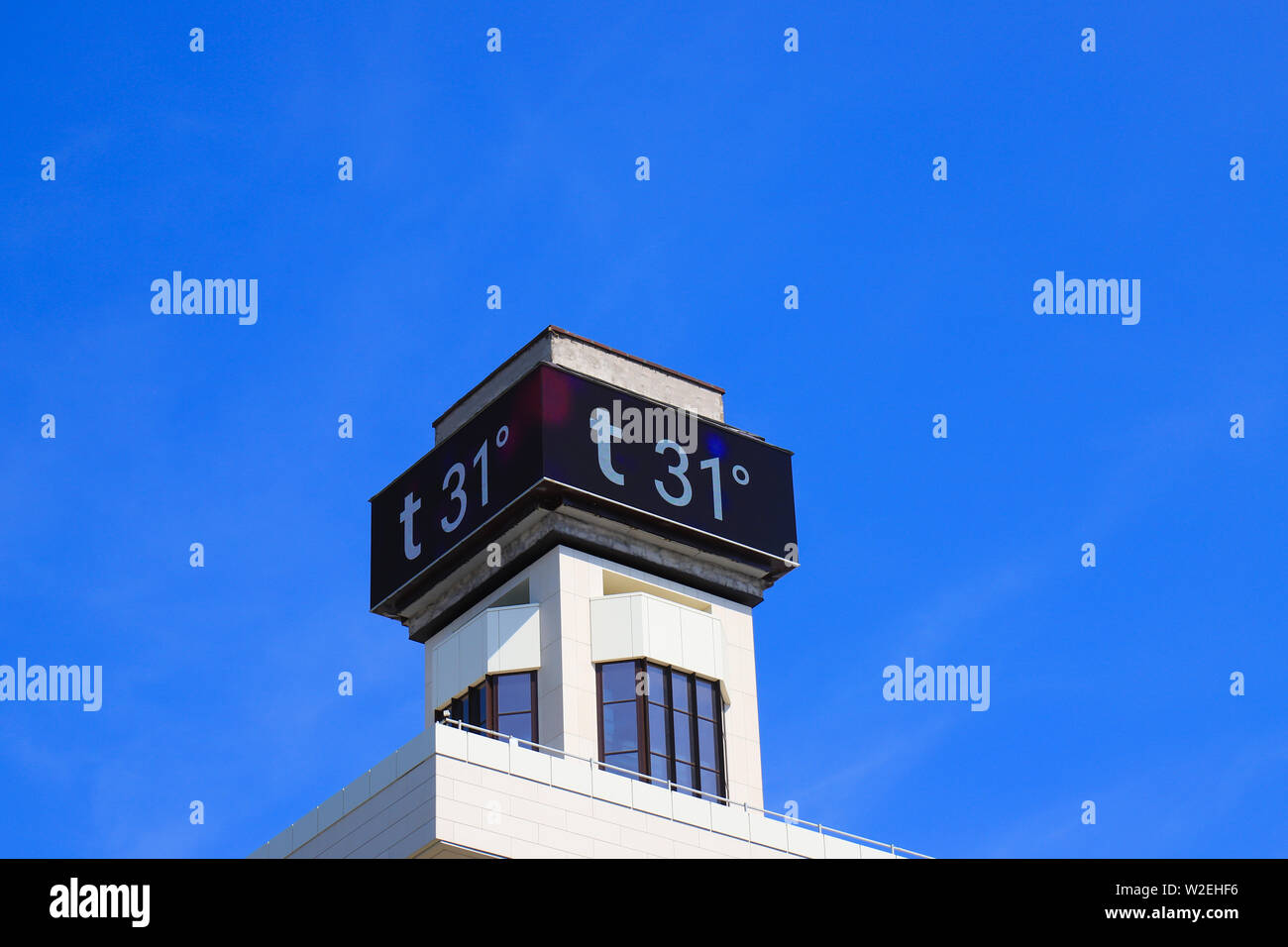 Electronic large thermometer on the building, indicating a high summer air temperature 31 degrees Celsius. Summer hot weather, heat Stock Photo