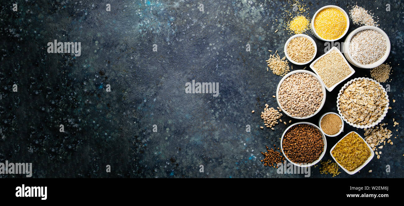 Selection of whole grains in white bowls rice, oats, buckwheat