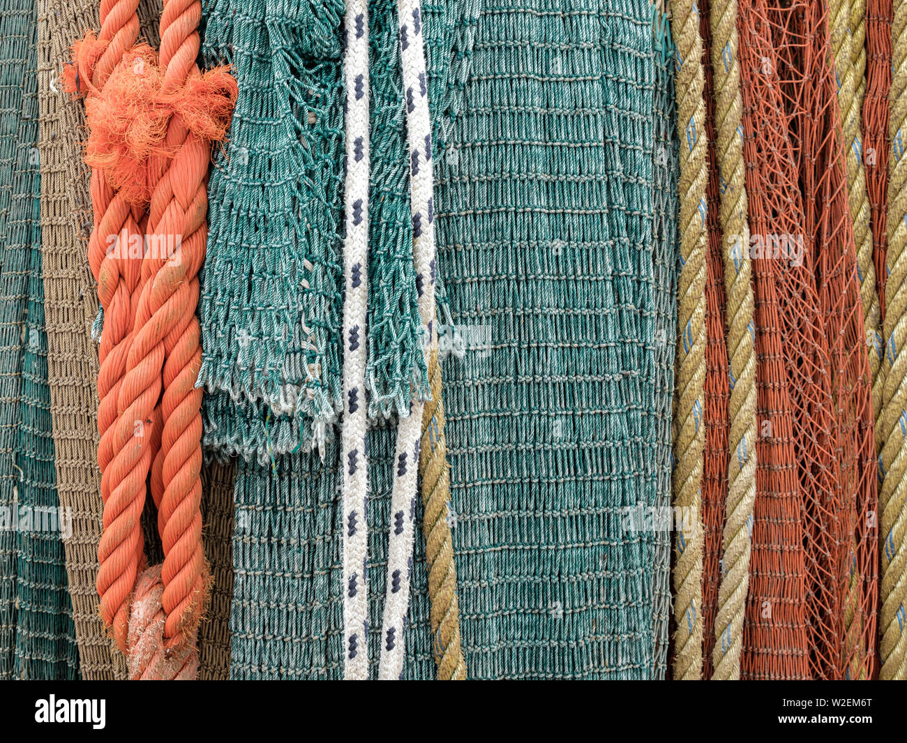 Neatly hanging fishing nets against a wall. Stock Photo
