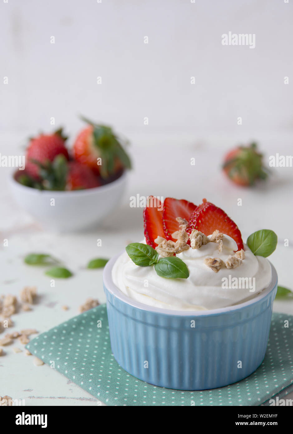 cup of ice cream with cream strawberries leaves of herbs with pastel color Stock Photo