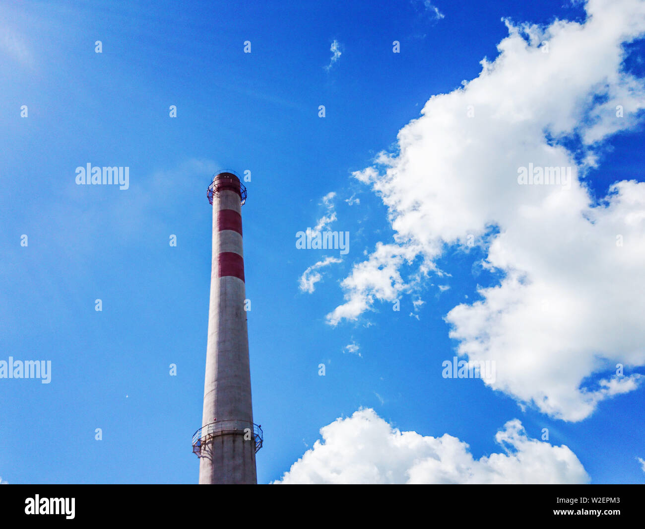Brick factory pipe on a background of blue sky with white clouds ...