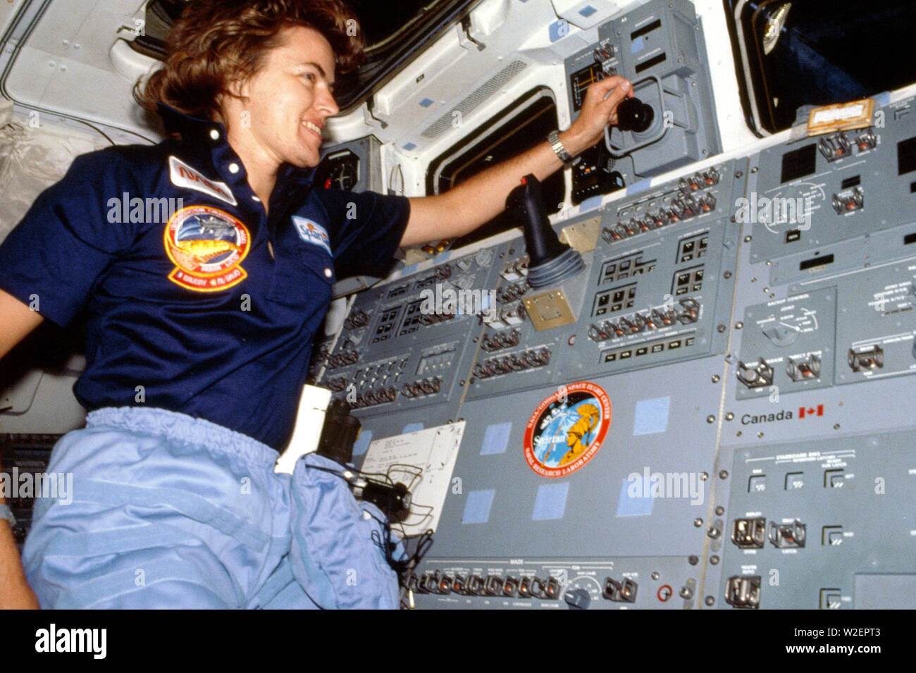 (17-24 June 1985) --- Astronaut Shannon W. Lucid monitors cargo bay activities with one of the satellite payloads aboard. Stock Photo
