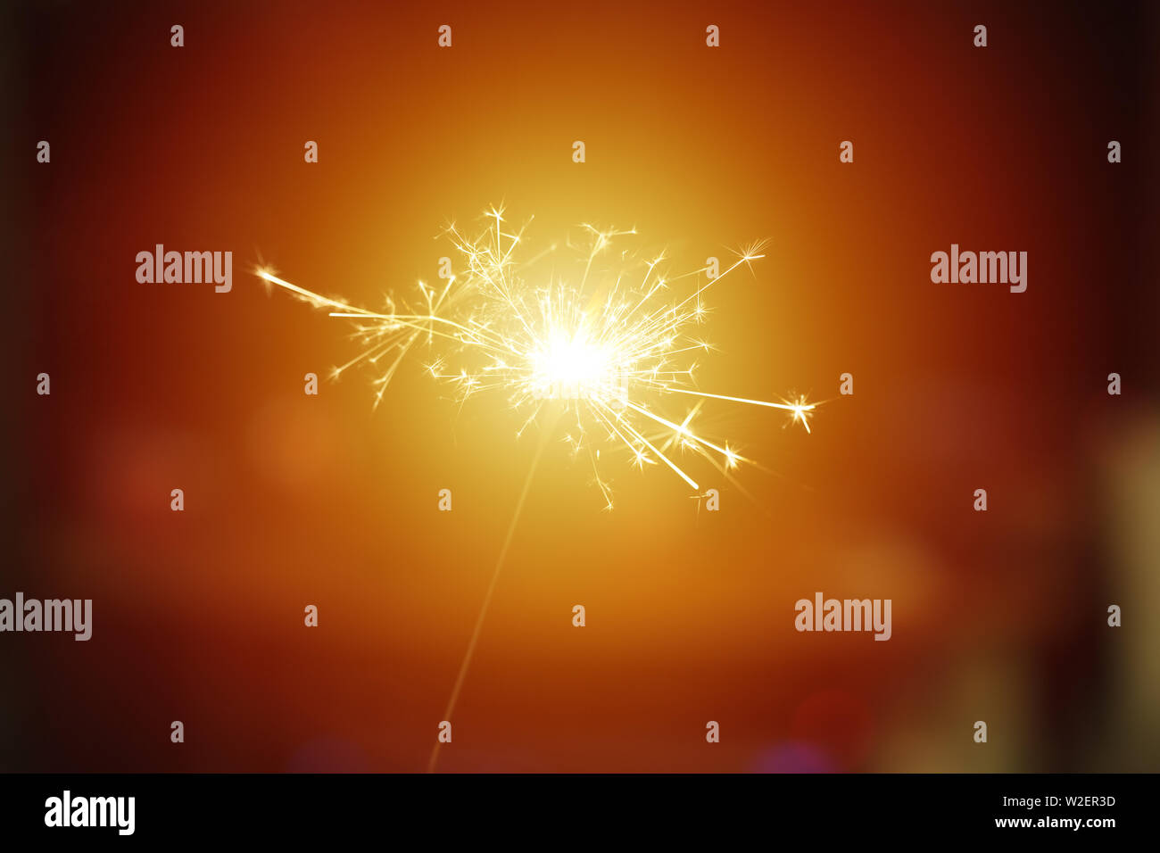Sparks from hand cold fireworks bright sun orange brown background Stock Photo