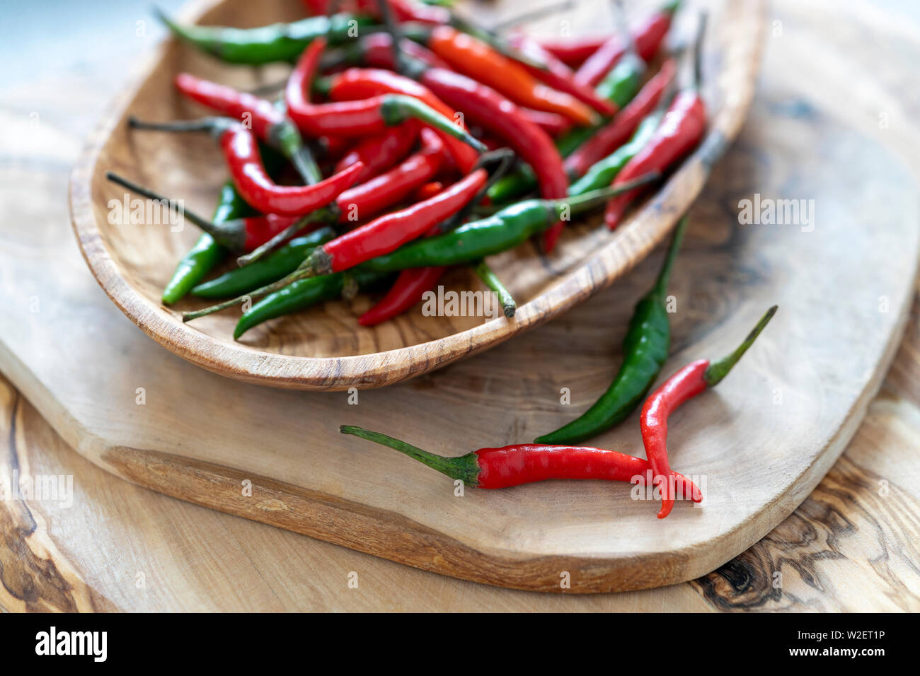 Red and green chilli's in a wooden bowl Stock Photo