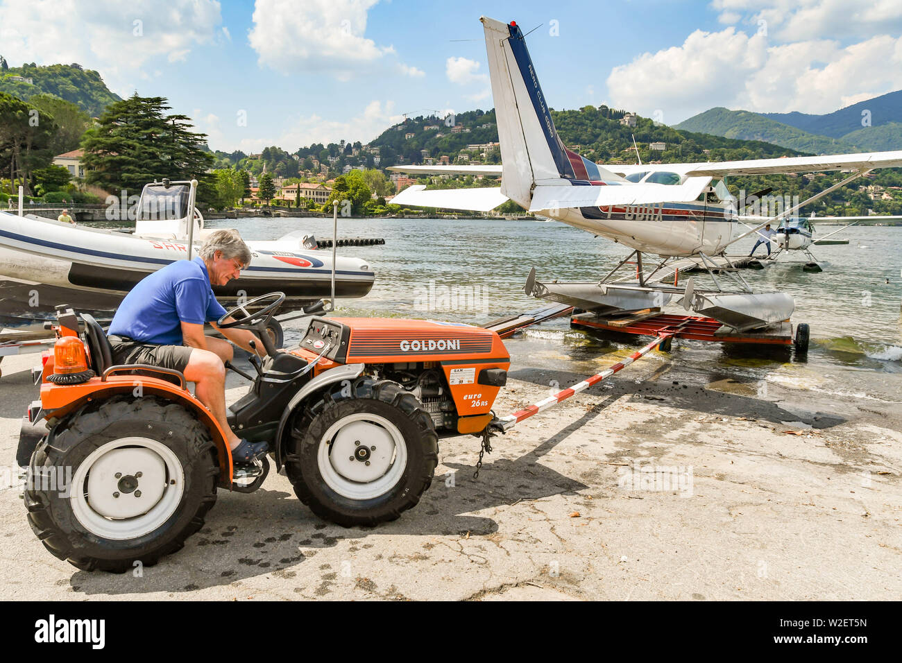 COMO, LAKE COMO, ITALY - JUNE 2019: Floatplane operated by the Aero Club Como being pushed by a small tractor into the waters of Lake Como. Stock Photo
