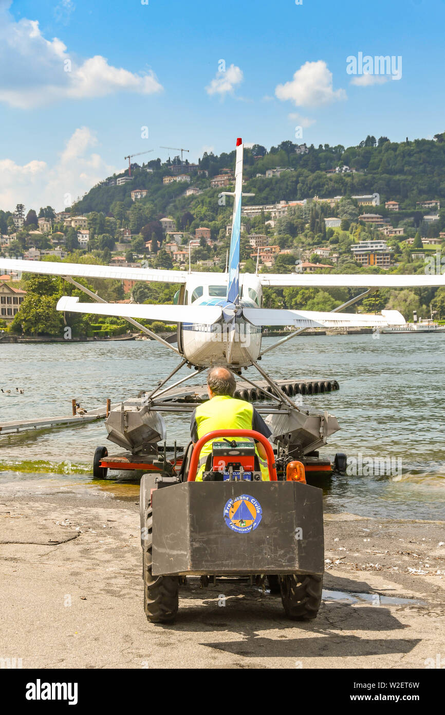 COMO, LAKE COMO, ITALY - JUNE 2019: Floatplane operated by the Aero Club Como being pushed by a small tractor into the waters of Lake Como in the town Stock Photo