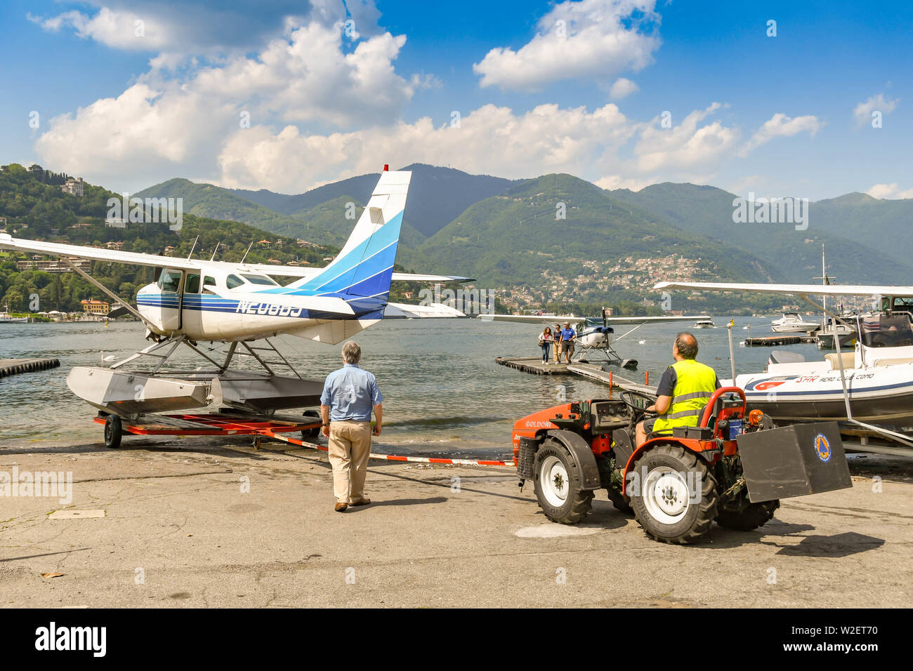 COMO, LAKE COMO, ITALY - JUNE 2019: Float plane operated by the Aero Club Como being pushed by a small tractor into the waters of Lake Como Stock Photo