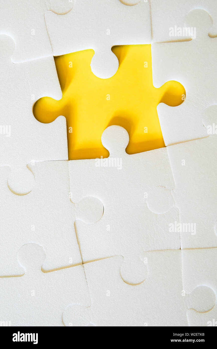Multiple white puzzle pieces put together without one piece. View from above. Stock Photo