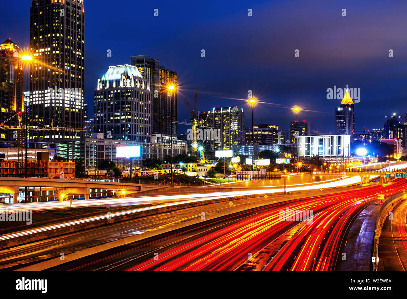 Atlanta, USA. Illuminated Midtown in Atlanta, USA at night. Car traffic, illuminated buildings and dark sky. Car traffic trails Stock Photo