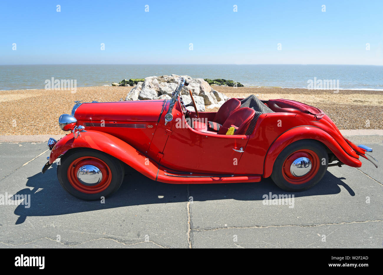 Classic Red Singer Motor Car Parked on Seafront Promenade. Stock Photo