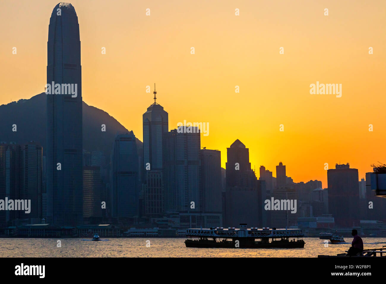Sunset skyline and ferry, Victoria harbour, Hong Kong, SAR, China Stock Photo