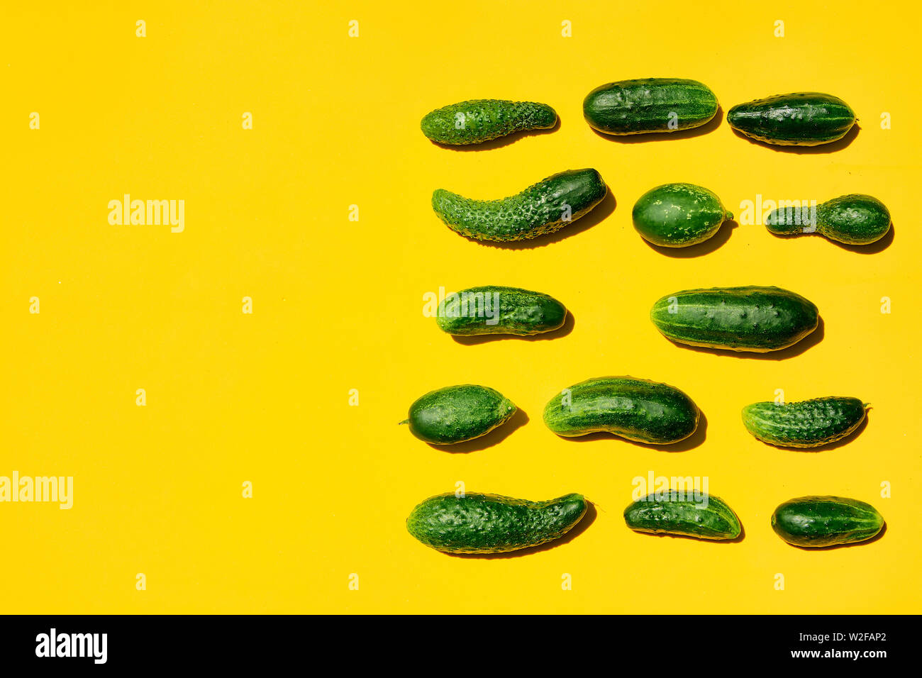 Different sizes forms cucumbers pattern on a light yellow background ...