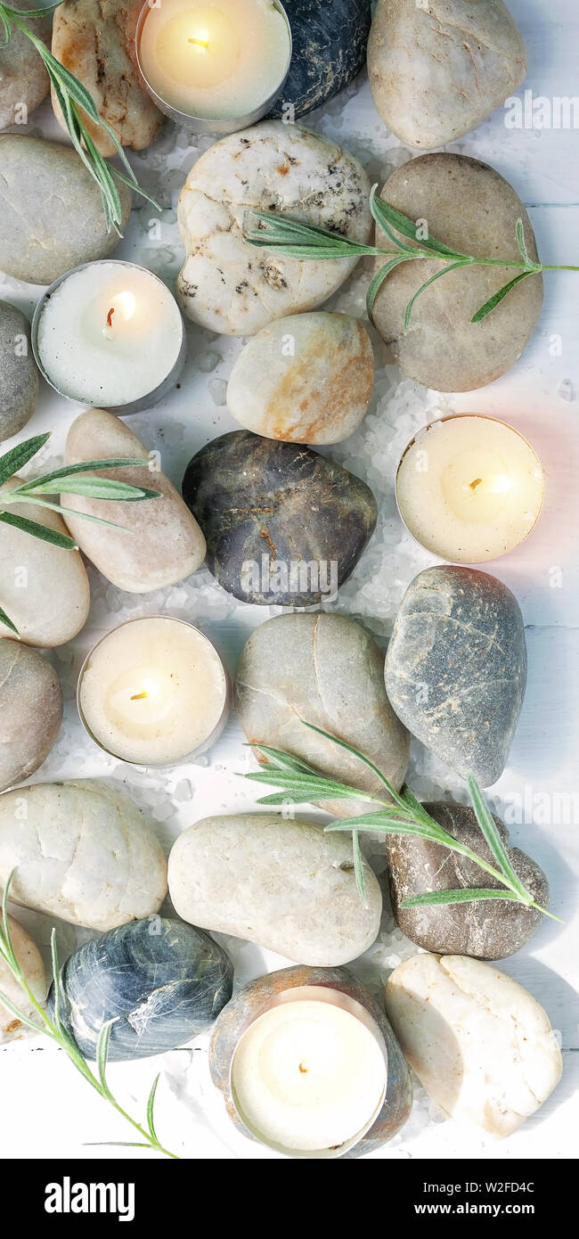 Vertical SPA banner. Sea pebbles, bamboo shoots, scented candles, sea salt on a light wooden background Stock Photo