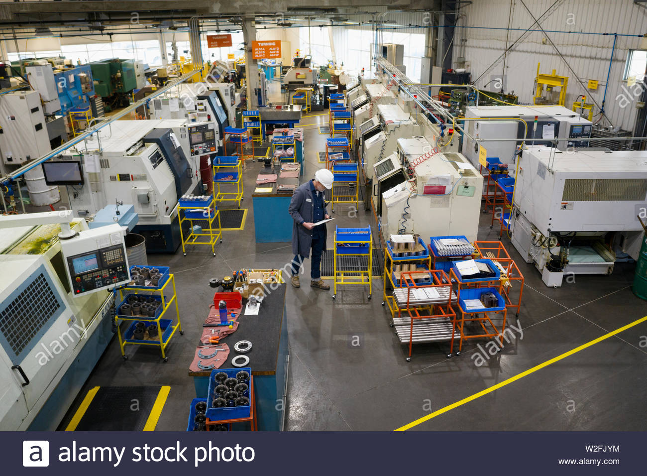 Supervisor examining equipment in machine shop Stock Photo Alamy