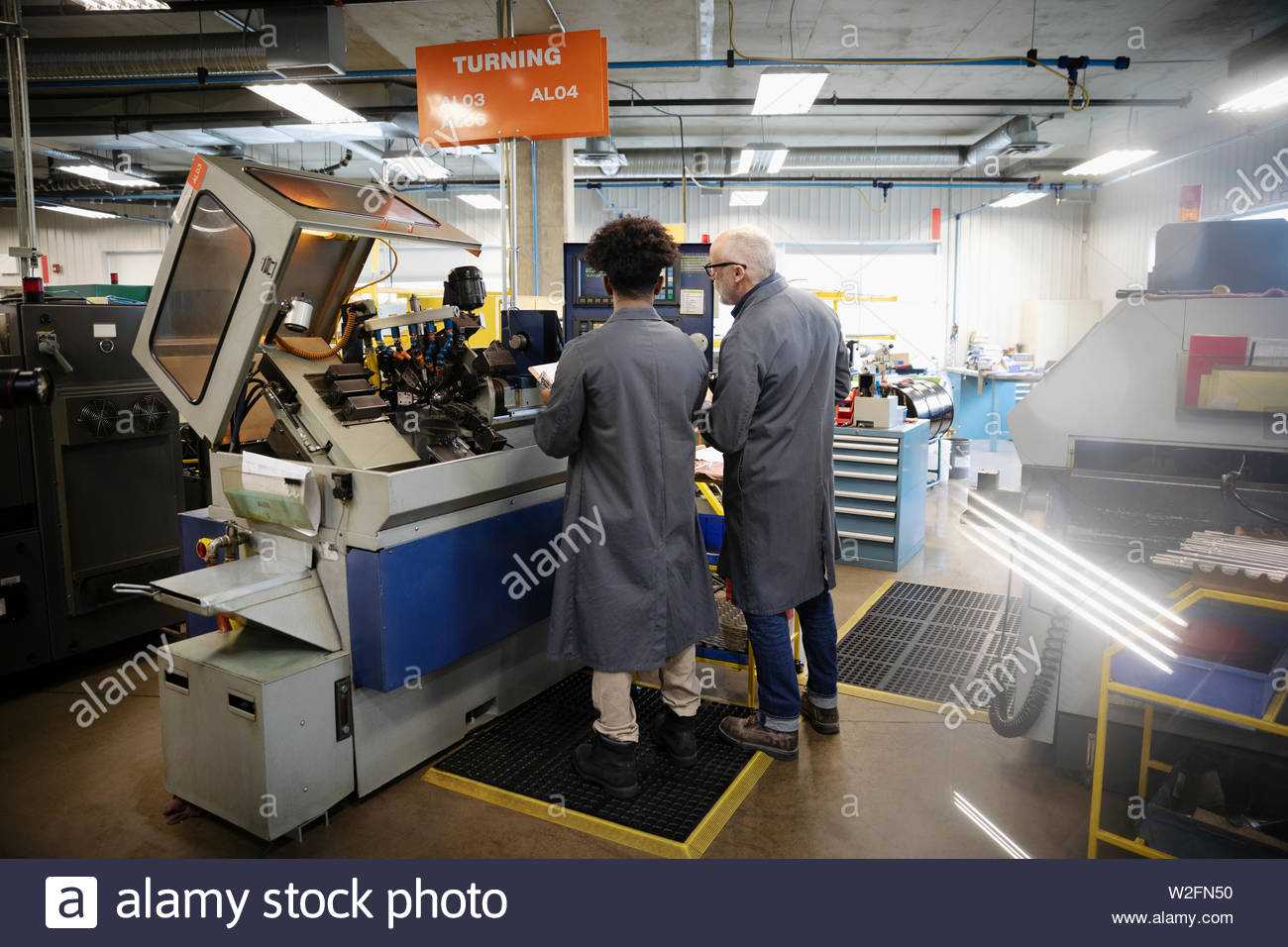 Machinists Operating Machinery In Factory Stock Photo Alamy